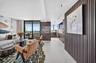 Kitchen featuring flat-panel wood-finish cabinetry, integrated appliances, stone backsplash, built-in dry bar, and large-format tile flooring