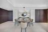 Stone countertop, undermount sink, matte black hardware, stone-finish wall cladding, and wood-finish cabinetry