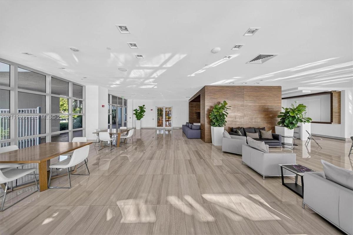 Dark wood-finish cabinetry, built-in wet bar, stone-surface counters, light wood-finish flooring, and minimalist linear recessed lighting