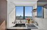 Private covered balcony featuring neutral tile flooring, a textured concrete ceiling, and a metallic horizontal-bar railing