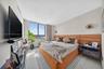 Custom floor-to-ceiling wood-finish cabinetry with integrated LED lighting, recessed wall-mounted reading sconces, and a multi-speed ceiling fan