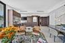 Custom floor-to-ceiling upholstered wall paneling, floating dark-stone finish bedside tables, large-format window, and minimalist disc-style wall scon