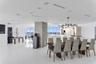 Open-concept interior featuring large-format tile flooring, exposed concrete structural column, recessed lighting, modern multi-globe chandelier, and 