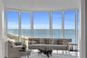 Floor-to-ceiling panoramic windows featuring expansive ocean and coastal scenery