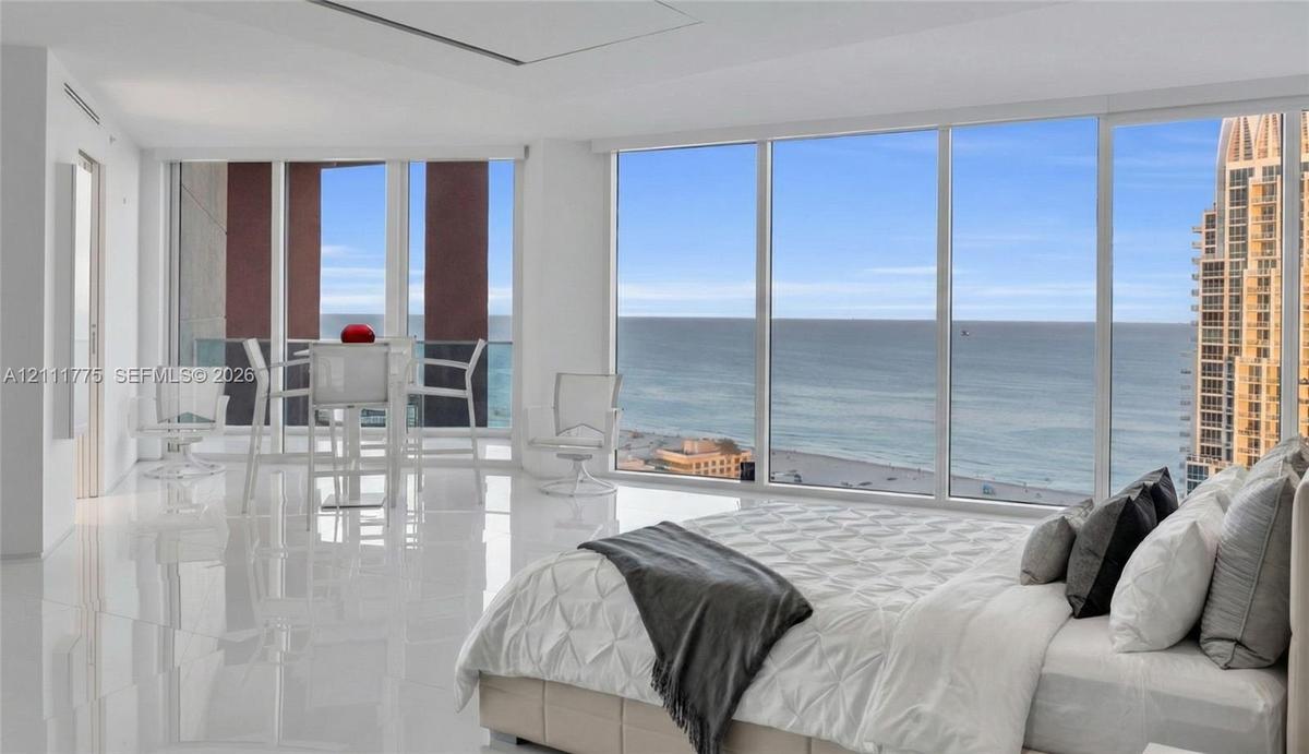 Floor-to-ceiling windows, polished tile flooring, and integrated recessed lighting