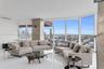 Floor-to-ceiling glass walls, polished stone-finish flooring, and exposed concrete structural column