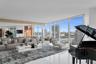 Floor-to-ceiling windows featuring panoramic urban and water scenery, polished white tile flooring, and mirrored wall accents