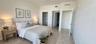 Spacious room featuring neutral tile flooring, neutral wall tones, and built-in closet storage