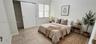 Neutral-toned ceramic tile flooring, sliding-door closet, and natural light via multi-pane window
