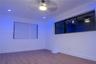 Neutral interior featuring wood-finish flooring, recessed lighting, a ceiling fan with integrated lighting, and multiple windows