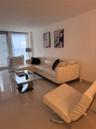 Polished tile flooring, full-height windows, and ocean backdrop