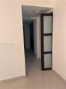 Dark-framed door with three frosted glass panels and high-gloss tile flooring
