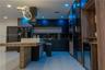 Modern kitchen featuring flat-panel cabinetry, stone-patterned backsplash, wood-finish kitchen island with stone countertop, built-in dual wall ovens,