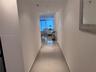 Hallway featuring large-format polished tile flooring and recessed ceiling lighting