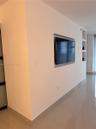Wall-mounted recessed television niche with integrated shelving and polished tile flooring