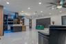 Open-concept living space featuring high-gloss tile flooring, recessed ceiling lighting, a kitchen island with built-in cabinetry, dual wall-mounted o