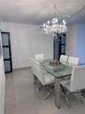 Polished tile flooring, ornate crystal chandelier, and dark-framed doors with frosted glass inserts
