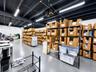 Industrial-style workspace featuring an expansive open floor plan, exposed dark-toned ceiling joists, durable floor coating, and high-output linear li