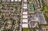 Aerial perspective of a multi-unit industrial complex featuring flat roof architecture, paved surface parking, and direct street access