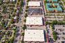 Aerial perspective of industrial warehouse complex featuring paved parking areas, multi-bay loading access, flat roof systems, and proximity to major 