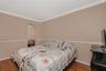 Room featuring wood-finish flooring, crown molding, chair rail trim, and mirrored sliding closet doors