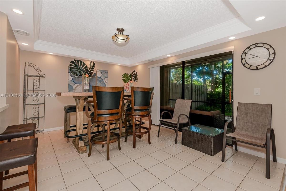 Ceramic tile flooring, crown molding, recessed lighting, and sliding glass doors