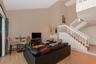 Living area featuring vaulted ceilings, wood-finish flooring, a built-in wet bar, and a wooden staircase with white balusters