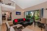 Vaulted ceiling, wood-finish flooring, white railing mezzanine, and floor-to-ceiling glass sliding doors