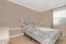 Neutral wall tones, crown molding, chair rail detailing, ceramic tile flooring, and a large window with horizontal blinds