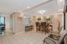 Open-concept area featuring light-toned tile flooring, recessed ceiling lighting, and a pass-through opening