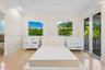 Tray ceiling, stone tile flooring, recessed lighting, and double glass doors opening to a balcony