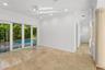 Interior space featuring polished stone flooring, recessed lighting, decorative columns, and floor-to-ceiling sliding glass doors with exterior pool e