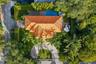 Aerial perspective featuring a multi-gabled clay tile roof, a circular paved driveway, a swimming pool, a separate spa, and mature landscaping