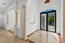 Foyer featuring high ceilings, stone columns with decorative capitals, stone flooring with decorative inlays, recessed wall niches, and double entry d