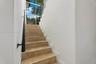 Staircase featuring natural stone treads, wrought iron railing, and floor-to-ceiling windows