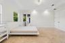 Tray ceiling featuring a decorative chandelier, polished stone flooring, and dual French doors