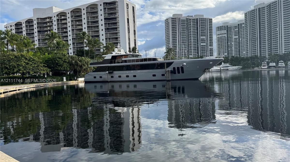 Waterfront property featuring a concrete bulkhead, deep-water canal access, and mature perimeter landscaping