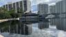 Waterfront property featuring a concrete bulkhead, deep-water canal access, and mature perimeter landscaping