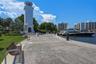 Waterfront promenade featuring a stone-paver walkway, a lighthouse-style architectural tower, and direct water access