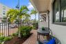 Covered patio featuring brick pavers, stone-accented columns, and integrated outdoor lighting