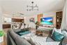 Open-concept living space featuring wood-finish cabinetry, a floating media console with backlighting, vertical wood slat wall accents, and a modern m