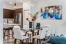 Kitchen featuring dark wood-finish cabinetry, stainless steel appliances, quartz countertops, and a modern geometric pendant light