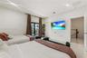 Light-filled interior featuring neutral-toned tile flooring, recessed ceiling lighting, and a glass sliding door providing access to a private balcony