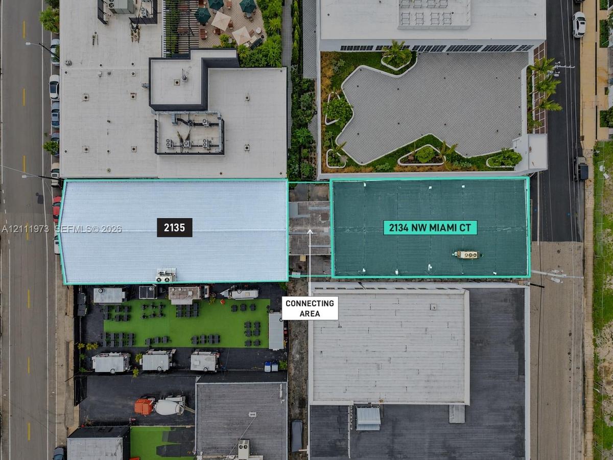 Aerial perspective of two distinct structures featuring a centralized corridor, dual-roof configurations, and surface-level hardscaping