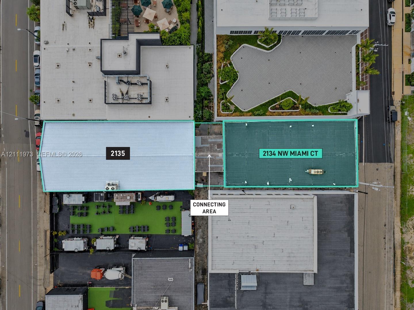 Aerial perspective of two distinct structures featuring a centralized corridor, dual-roof configurations, and surface-level hardscaping