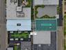 Aerial perspective of two distinct structures featuring a centralized corridor, dual-roof configurations, and surface-level hardscaping
