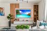 Custom media wall featuring vertical wood slat paneling, a recessed back-lit mount, a built-in floating console, and integrated full-height shelving