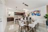 Kitchen featuring dark wood-finish cabinetry, solid-surface countertops, recessed lighting, pendant light fixtures, and large-format tile flooring