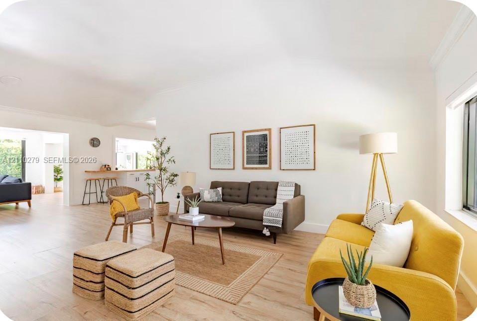 Open-concept interior featuring high vaulted ceilings, wood-finish flooring, and crown molding