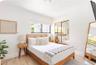 Bright room featuring wood-finish flooring, a horizontal window, and floor-to-ceiling mirrored closet doors